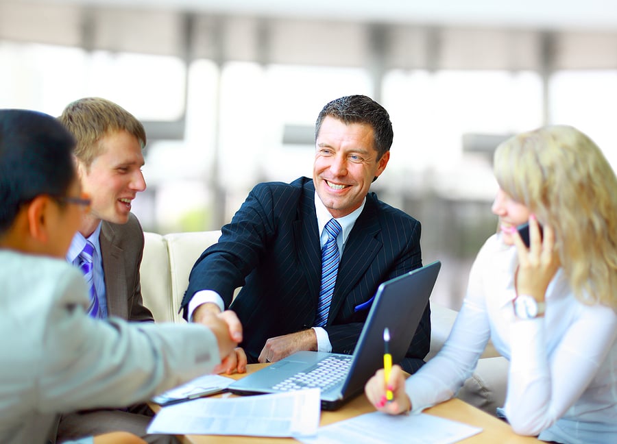 Businessman shaking hands with a colleague at a meeting table