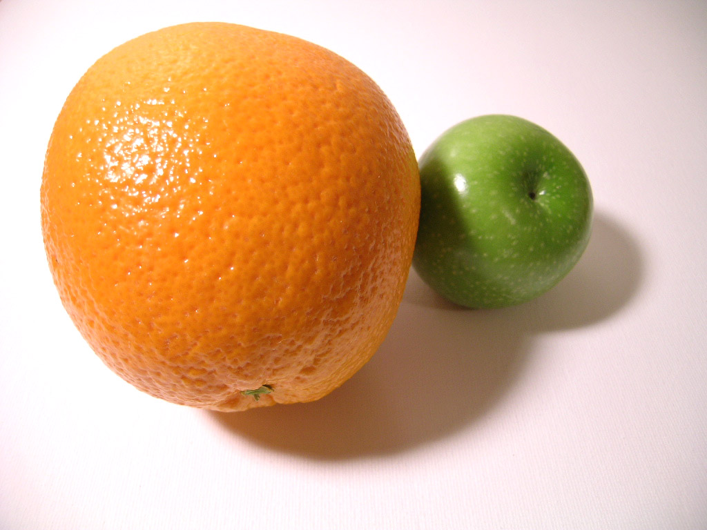 An orange and a small apple side by side