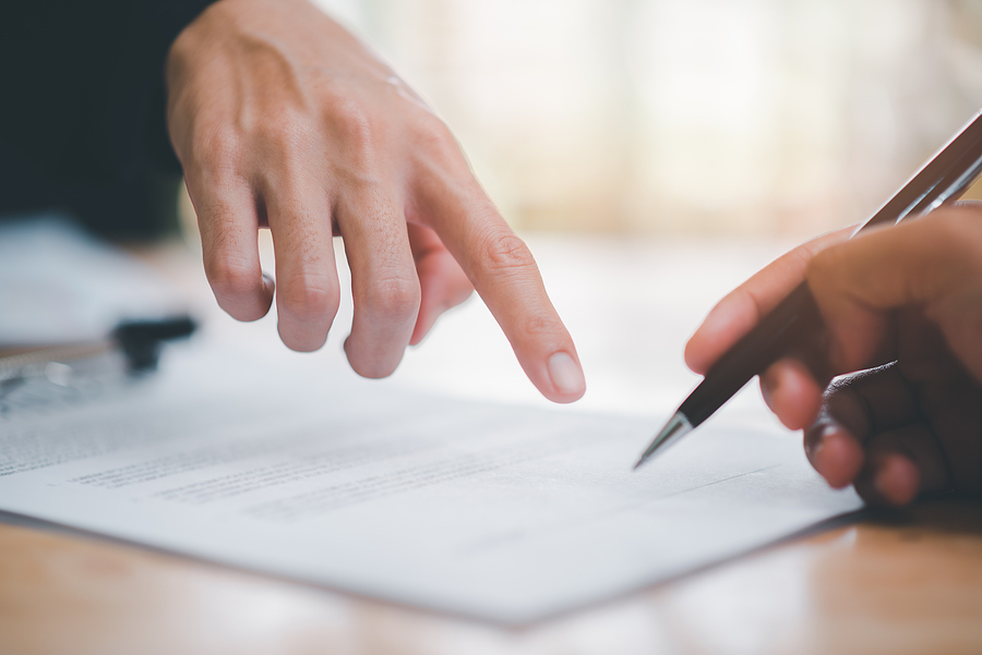 Two people reviewing and signing a document together