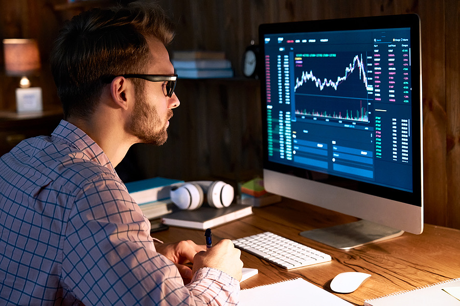 Trader analyzing stock charts on a desktop monitor