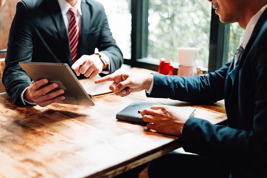 Two businessmen reviewing a tablet during a meeting