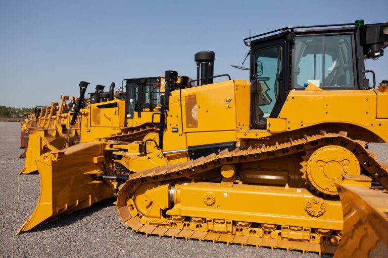 Row of yellow bulldozers parked at an equipment rental yard
